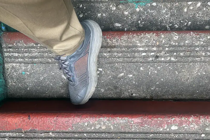 Close-up view of a shoe placed on a narrow Batu Caves stair step, highlighting the 31 cm step width and surface texture.
