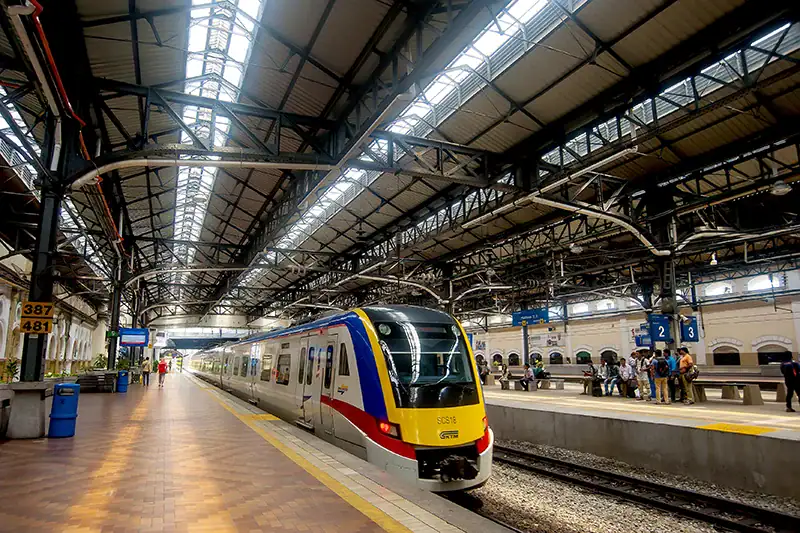 KTM Komuter train waiting at the platform — a popular and affordable way for tourists figuring out how to get to Batu Caves from Kuala Lumpur.