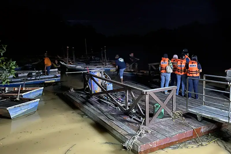 Tourists in life jackets standing on the old wooden jetty at Kampung Kuantan Fireflies Park before its 2023 upgrade