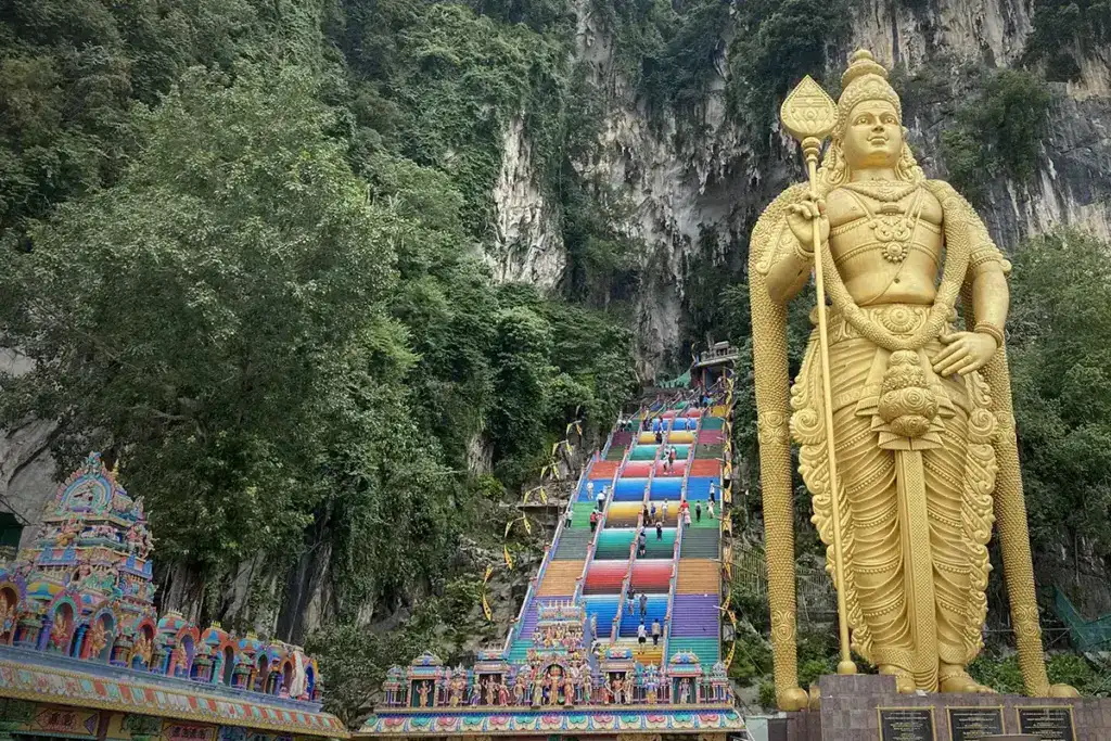 The golden Lord Murugan statue and the colorful staircase leading to Batu Caves, one of Malaysia’s most iconic cultural landmarks near Kuala Lumpur.