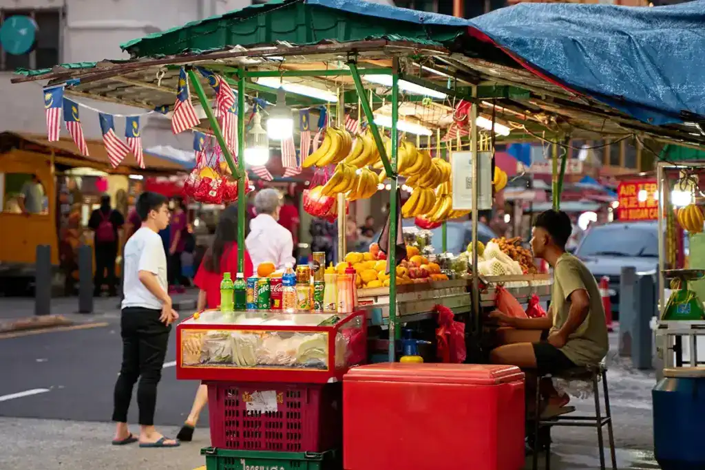 A street vendor at the Chinatown Kuala Lumpur market, a lively area often visited by travellers exploring KL tourist attractions and local food stalls.