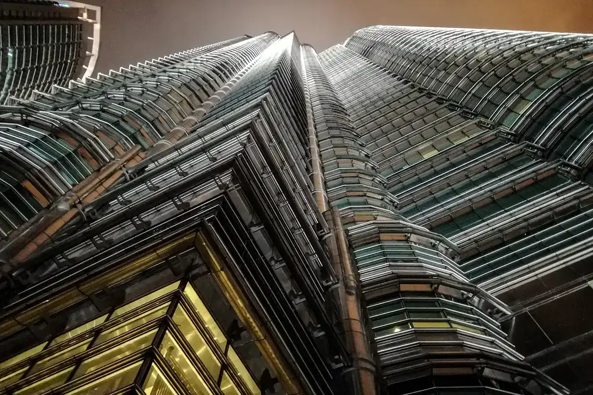 Close-up view of the Petronas Twin Towers at night, highlighting the building’s steel architecture and its role as one of the top attractions in Kuala Lumpur.