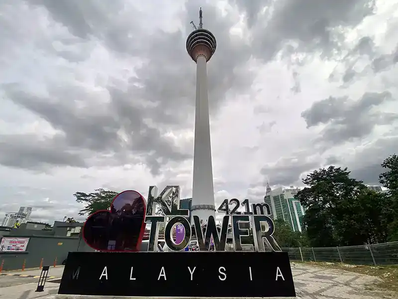 KL Tower with landmark sign at the base in Kuala Lumpur