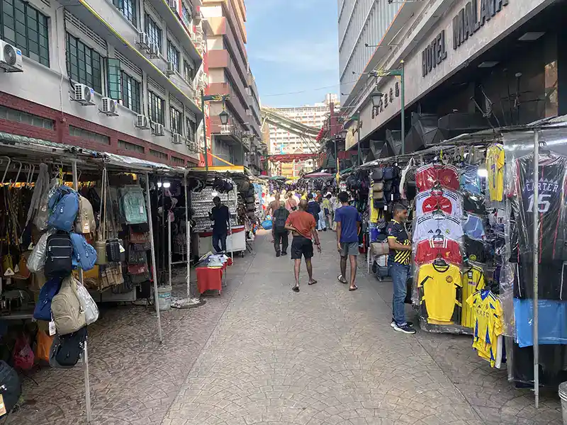 Tourists exploring the vibrant street market at Chinatown Kuala Lumpur along Petaling Street.