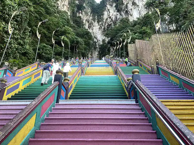 Climbing the rainbow staircase at Batu Caves, a popular thing to do in Kuala Lumpur for first-time visitors.