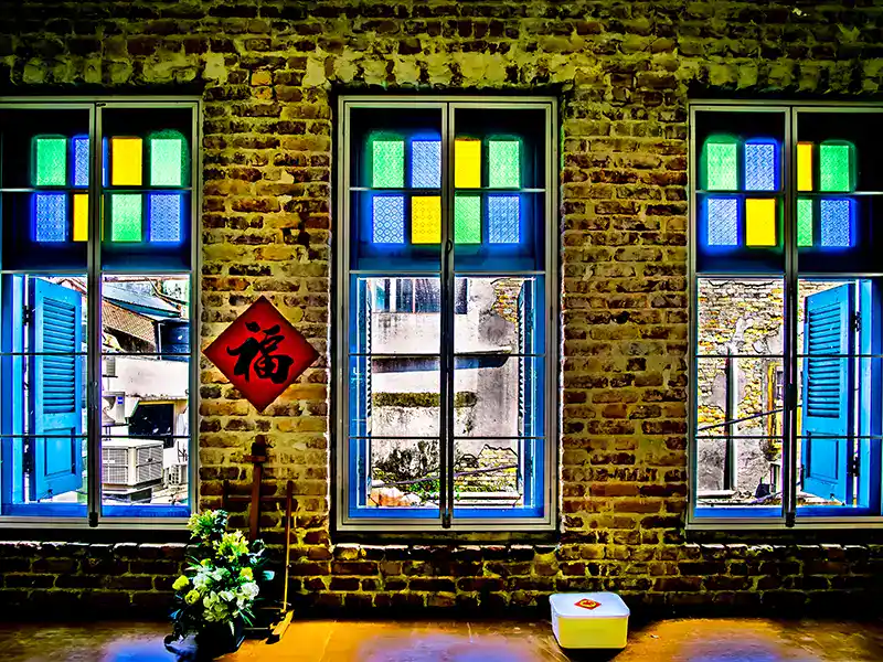 Traditional kopitiam café in Chinatown Kuala Lumpur with colourful windows and rustic brick interior