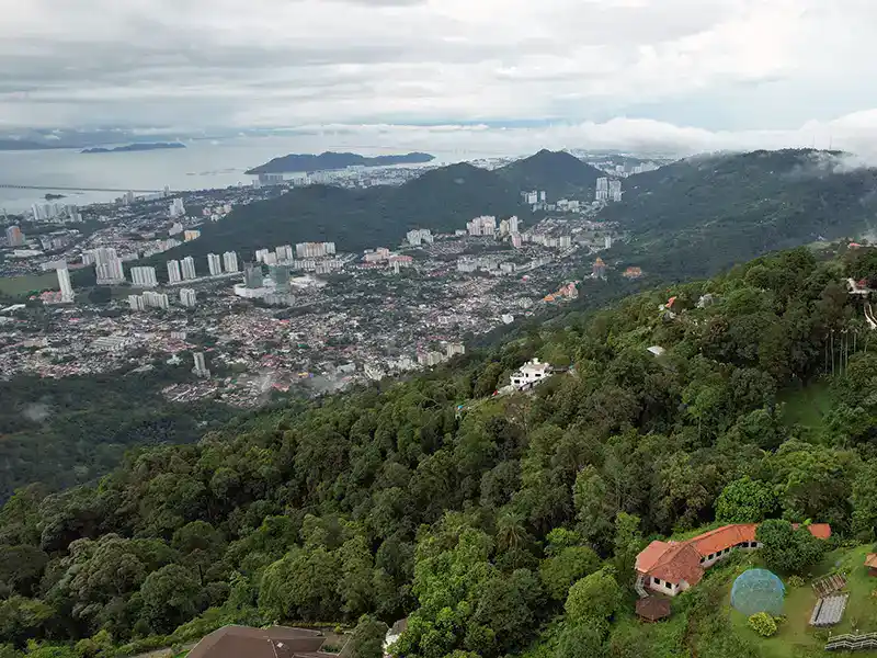 View of George Town and Penang Island from Penang Hill surrounded by forested hills