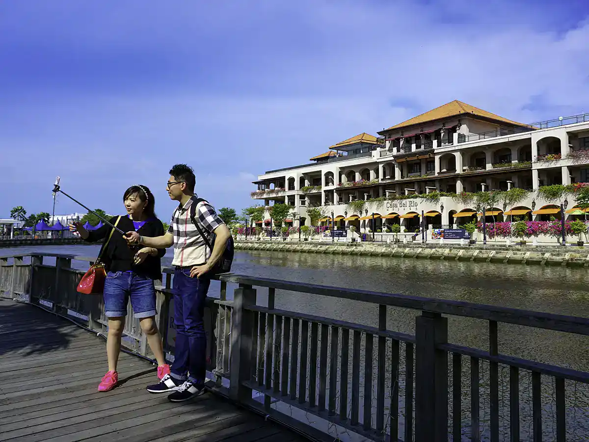 Visitors enjoying the Malacca riverbank while exploring the historic area
