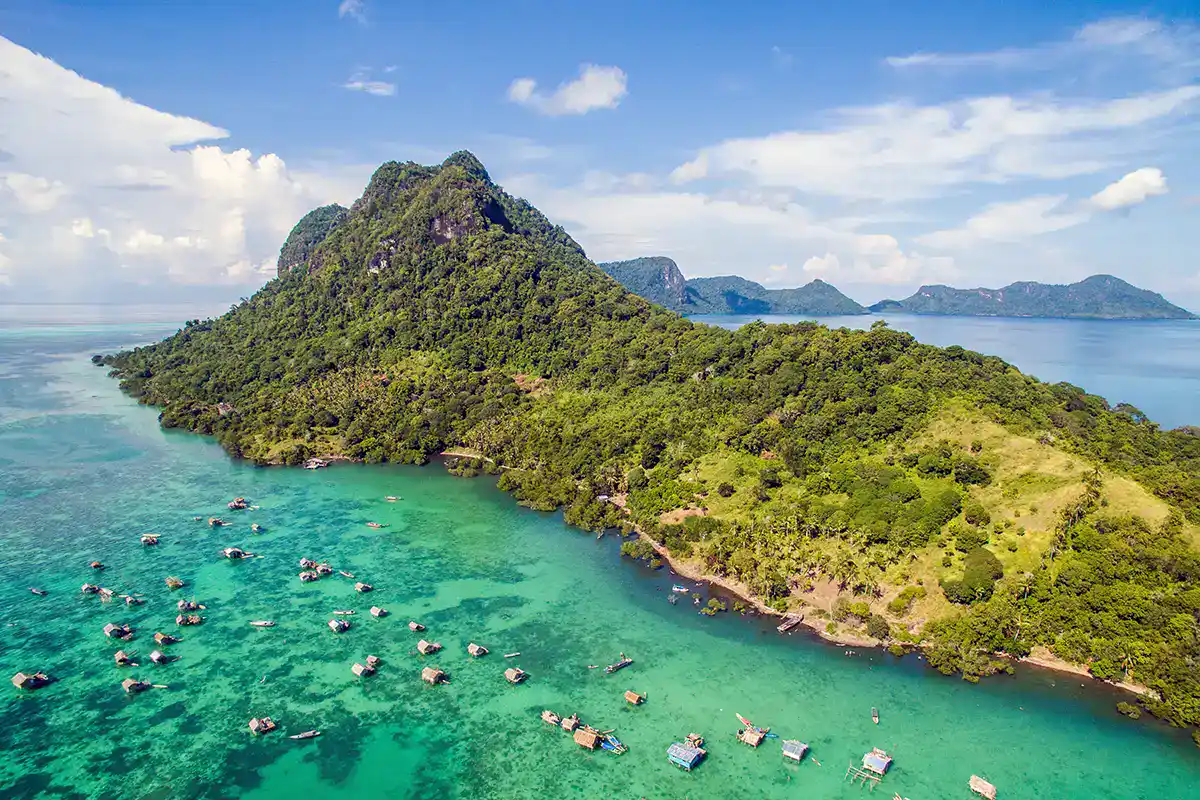 Tropical island landscape at Mabul–Dulang area in Malaysian Borneo with clear water and forested hills