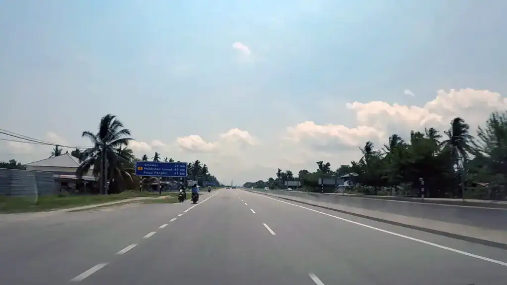Highway road sign showing directions toward Lumut and Pangkor Island ferry terminals
